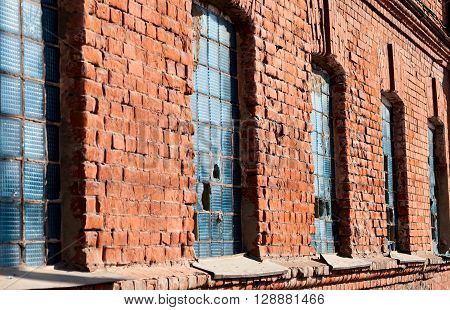 Windows broken old glass bricks in the wall. Fragment of a building of bricks.