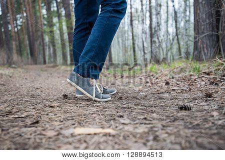 Feet of a running woman in the forest.