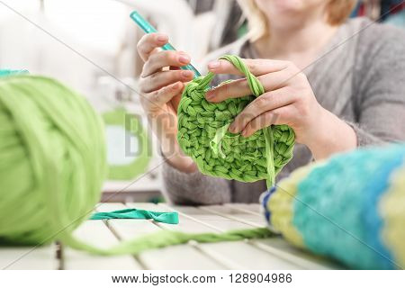 Handicraft, knitting crochet. The woman knits crochet.