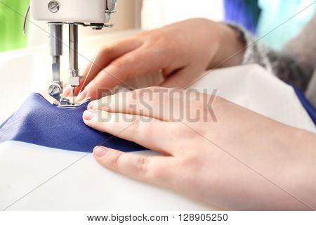 Woman sewing on the sewing machine .
