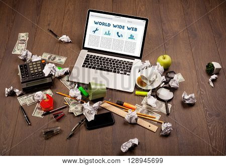 Laptop computer on wooden desk with office suplies