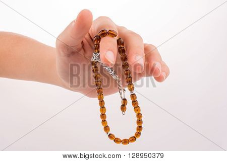 Hand holding a tespih on a white background