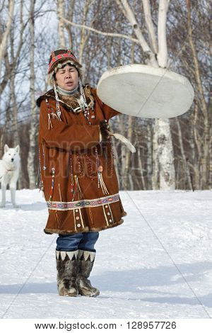 KAMCHATKA RUSSIA - FEB 5 2012: Woman in Koryak national dress dancing beats the tambourine and singing. Concert Koryak National Folklore Dance Group. Eurasia Russian Far East Kamchatka Region.