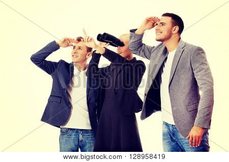 Business team looking into one direction-woman using binoculars