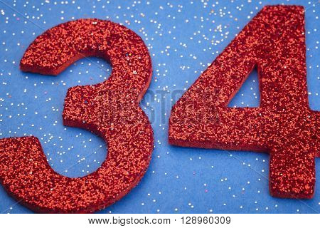 Number thirtyfour red color over a blue background. Anniversary. Horizontal