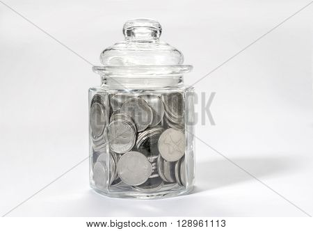 Saving money - a concept. UAE dirham coins in a glass bottle.