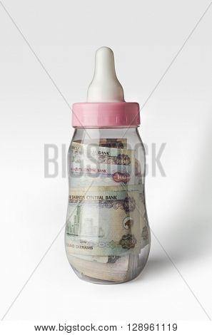 Assorted UAE dhs currency notes filled inside a feeding bottle. Creative concept. 'Growing economy' - a creative idea.