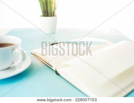 Books And Pen On The Blue Table. Flower, Cup Of Coffee. Book, White Background. Blue Pen On The Whit