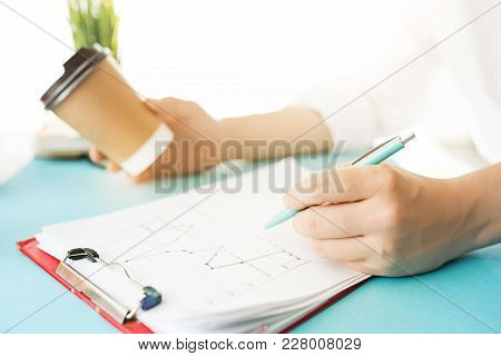 Male Hands Holding Pen, Writing. Side View On Man On Trendy Color Blue Desk. Man And Stilish Workpla