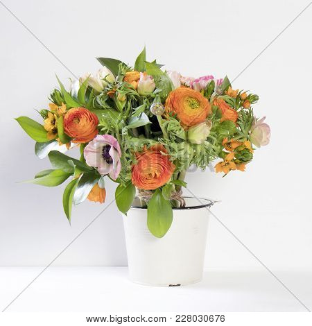 A Wedding Bouquet Of Buttercups, Anemones And Ruscus On The White Background