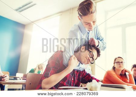 education, bullying, violence, aggression and people concept - student boy suffering of classmate mockery