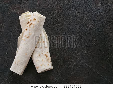 Armenian Flat Bread Lavash. Pita Bread On Black Cement Background. Copy Space. Top View Or Flat-lay.