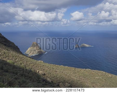 View On Rock In The Sea El Draguillo With Green Hills And Dramatic Blue Sky White Clouds In Anaga Mo
