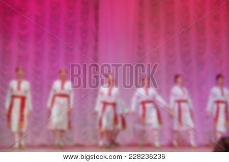 Folk Dances Of Children And Teens Theme Abstract Blur Background With Bokeh Effect. Teens In Bright 