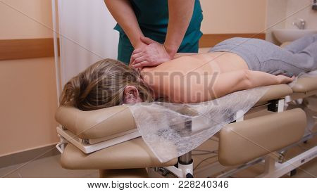 Chiropractor Massaging A Young Woman Lying On A Massage Table, Pushing On Her Back With His Elbow, S