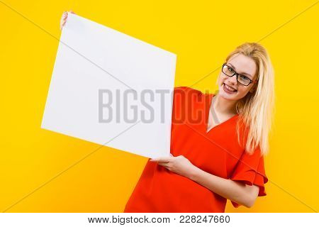 Portrait Of Attractive Happy Blonde Woman In Red Dress And Eyeglasses Isolated On Yellow Background 