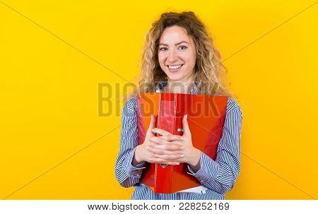 Portrait Of Attractive Smiling Businesswoman In Striped Shirt Isolated On Orange Background Holding 