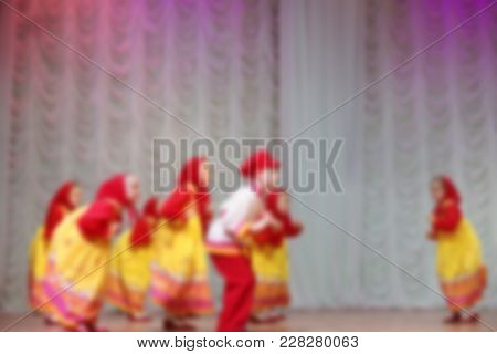 Folk Dances Of Children And Teens Theme Abstract Blur Background With Bokeh Effect. Teens In Bright 