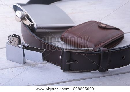 Gadgets And Accessories For Men On Light Wooden Background. Fashionable Men S Belt, Wallet, Lighter,