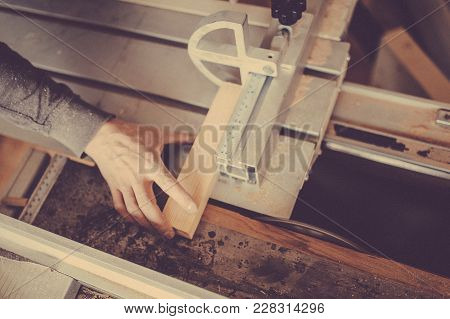 A Carpenter Works On Woodworking The Machine Tool. Toned Image.