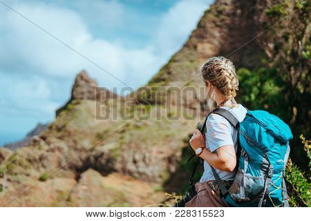 Woman With Camera And Backpack In Front Of The Arid Fins Of Rocks On Santo Antao Island, Cabo Verde.