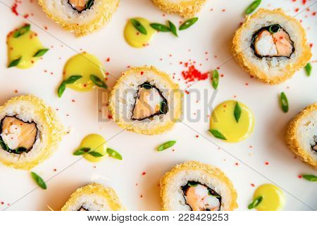 Close Up Delicious Sushi Rolls Put On White Surface With Drops Of Sauce And Caviar