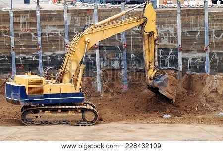 The Modern Excavator Performs Excavation Work On The Construction Site