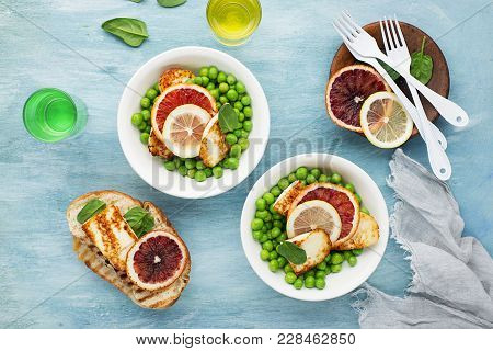 Green Young Peas, Cheese Haloumi, Lemon. Orange Salad With Slices Of Bread. Top View.