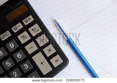 Calculator With A Blue Pen On A Tetrad