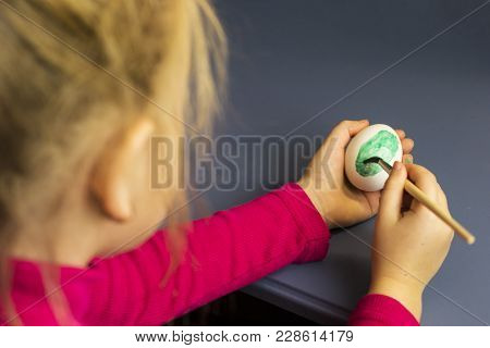 The Child Paints The Eggs. Preparing For Easter.