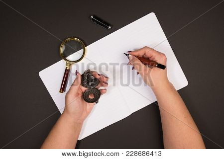 Holding A Pocketwatch While Makeing Some Notes In A Textbook