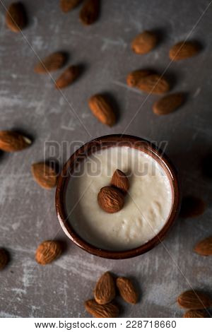 closeup of an earthenware bowl with menjar blanc, a desert made with almonds typical of Catalonia, Spain, on a rustic table