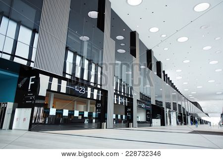 Part of hall of large airport with entrances to platforms alongside