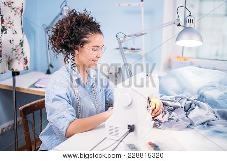 Tailor Wearing Blue Blouse And Having Flexible Ruler On Her Shoulders Working At Atelier. Working Ho