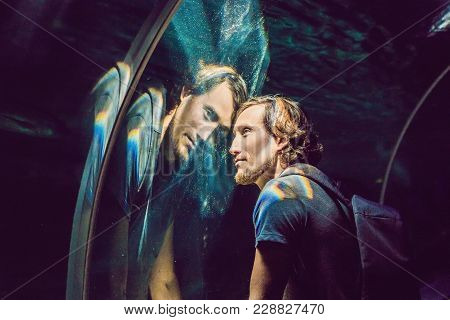 Man Looks At The Fish In The Aquarium.