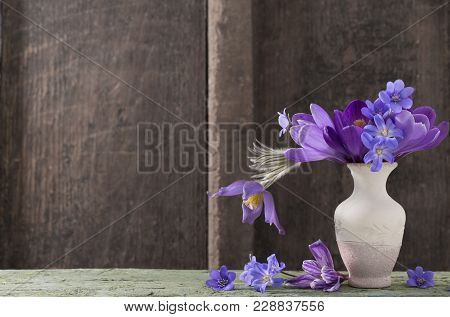 Spring Flowers In Vase On Wooden Background