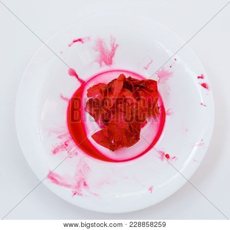 Red Blood Napkin Lies In The White Plate. View From Above