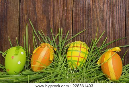 Easter Eggs In The Grass On A Wooden Background.happy Easter