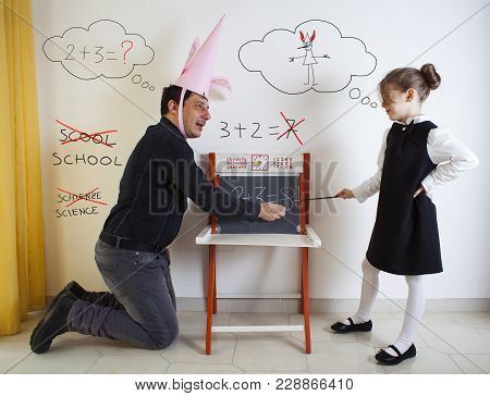 Little Girl Teaching Mathematics To An Adult Dunce On Little Chalkboard
