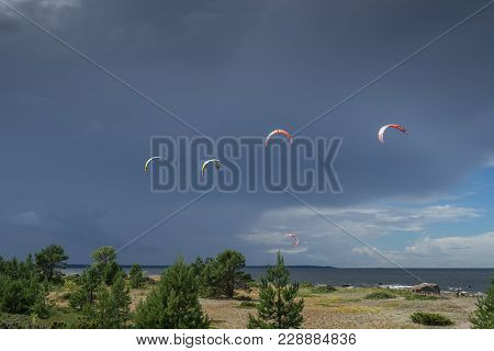 A kite surfer rides on the sea. Kites in the sky. Kite Boarding, extreme sport on Mohni, small islan