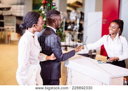 African Customer Buying A Vehicle At Car Dealership. Woman And Man Handshaking