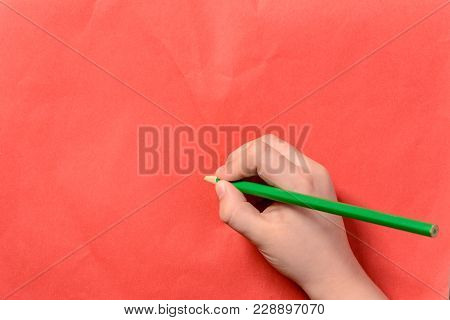 A Photo Of The Hands Of A Young Boy Holding Pencils And Pens On Colored Backgrounds