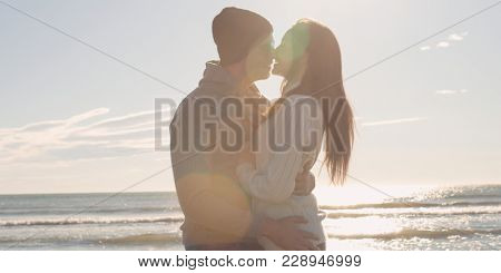 Cool Couple Laughing and hugging In Front Of Beach at beautiful autumn day