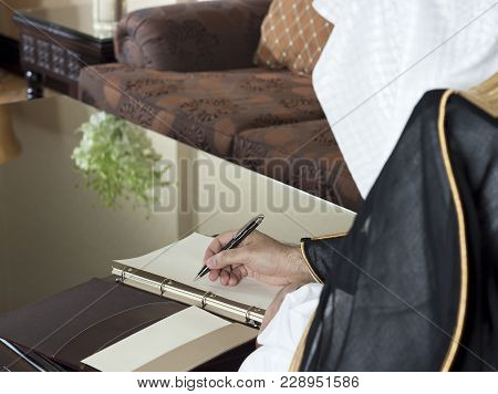 Saudi Arabian Man Hand Writing On A Notebook