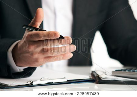 Businessman Sitting At The Table And Explaining Something, Close-up. Sales Clerk Insurer Talking Try