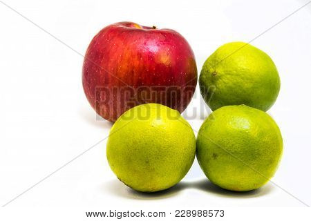 One Red Apple And Three Green Lime Isolated On White