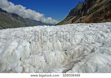 Ice Field Of The Bezengi Glacier Against The Background Of Mountain Slopes