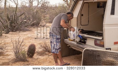 Baja California, Mexico - December 5ht, 2017: Mechanic Adding Oil To The Classic Volkswagen T3 Where