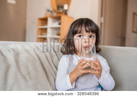 Addorable Little Girl Drinking Juice At Home