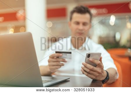 Man Using Smartphone And Laptop Computer For Online Shopping . Credit Card
